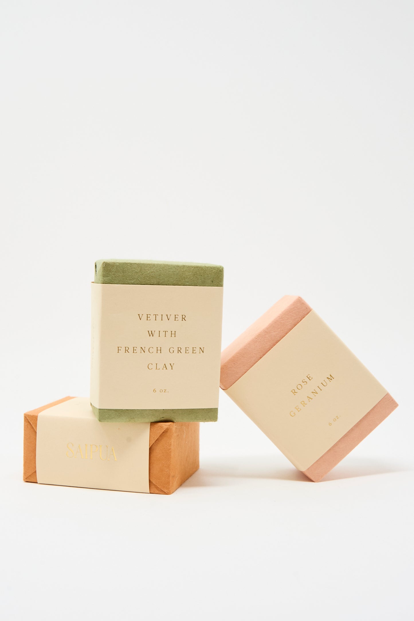Three rectangular bars of SAIPUA Soap in Vetiver with French Green Clay are stacked, each wrapped in cream-colored labels. This gentle facial soap is perfect for sensitive skin.