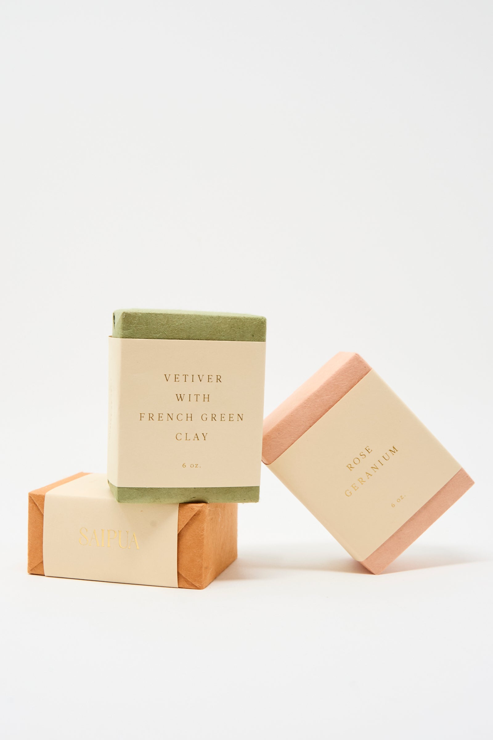 Three rectangular bars of SAIPUA Soap in Vetiver with French Green Clay are stacked, each wrapped in cream-colored labels. This gentle facial soap is perfect for sensitive skin.