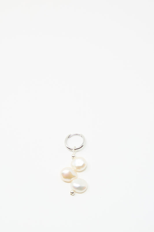 The Santangelo Baba Earring in Triple Baby, a sterling silver hoop featuring three elegant freshwater keshi pearls, is displayed against a plain white background.