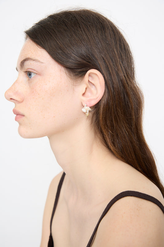 A woman with long brown hair and light skin wears a gold bee-shaped earring and the Santangelo Bebecita Single Earring in Double Shell, styled with a black spaghetti strap top against a plain white background.