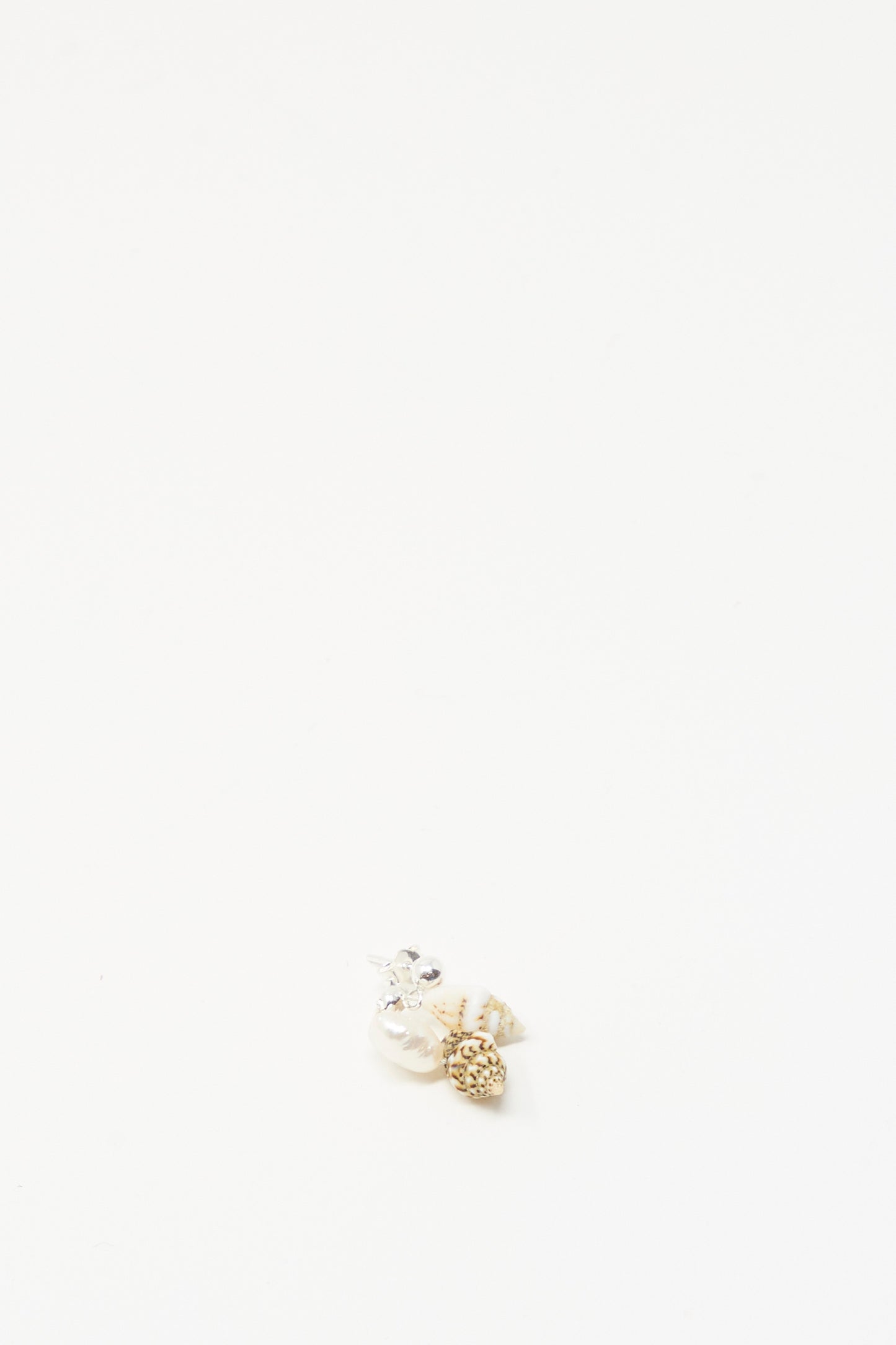 The Bebecita Single Earring in Double Shell by Santangelo features a cluster of assorted beads, a keshi pearl, and a tiny seashell arranged on a plain white background with ample empty space.