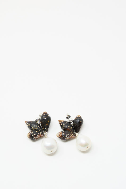 The Bepe Earrings in Pyrene by Santangelo are handmade drop earrings with black, spotted bow shapes and dangling keshi pearls, shown on a plain white background.