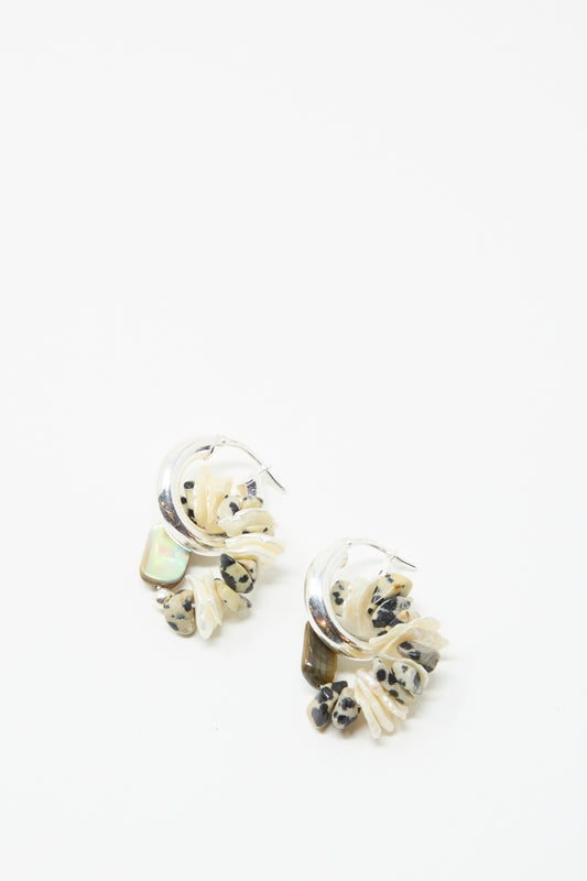 The Santangelo Che Bomba Earrings in Abalone Hoop feature sterling silver hoops with cream and black Dalmatian Jasper beads and a small opalescent stone, shown on a white background.
