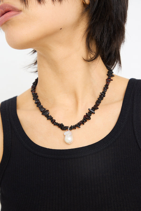 Woman wearing a black tank top and a Santangelo Kitano Necklace in Black with a single fireball pearl pendant.