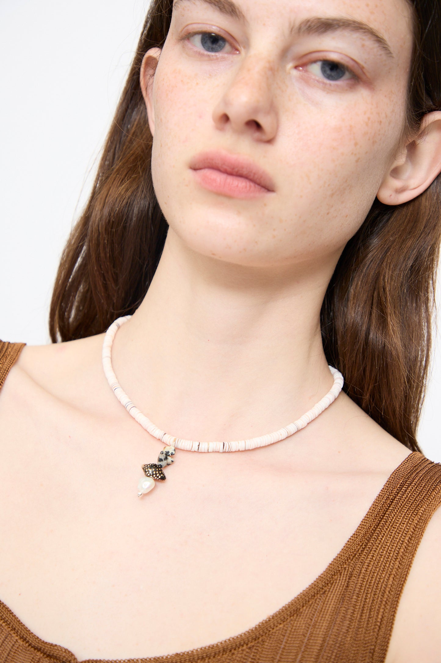 A woman wears the Santangelo Pronto Necklace in Heishi Dalmatian Stack with a brown tank top, shown from the shoulders up against a plain background.
