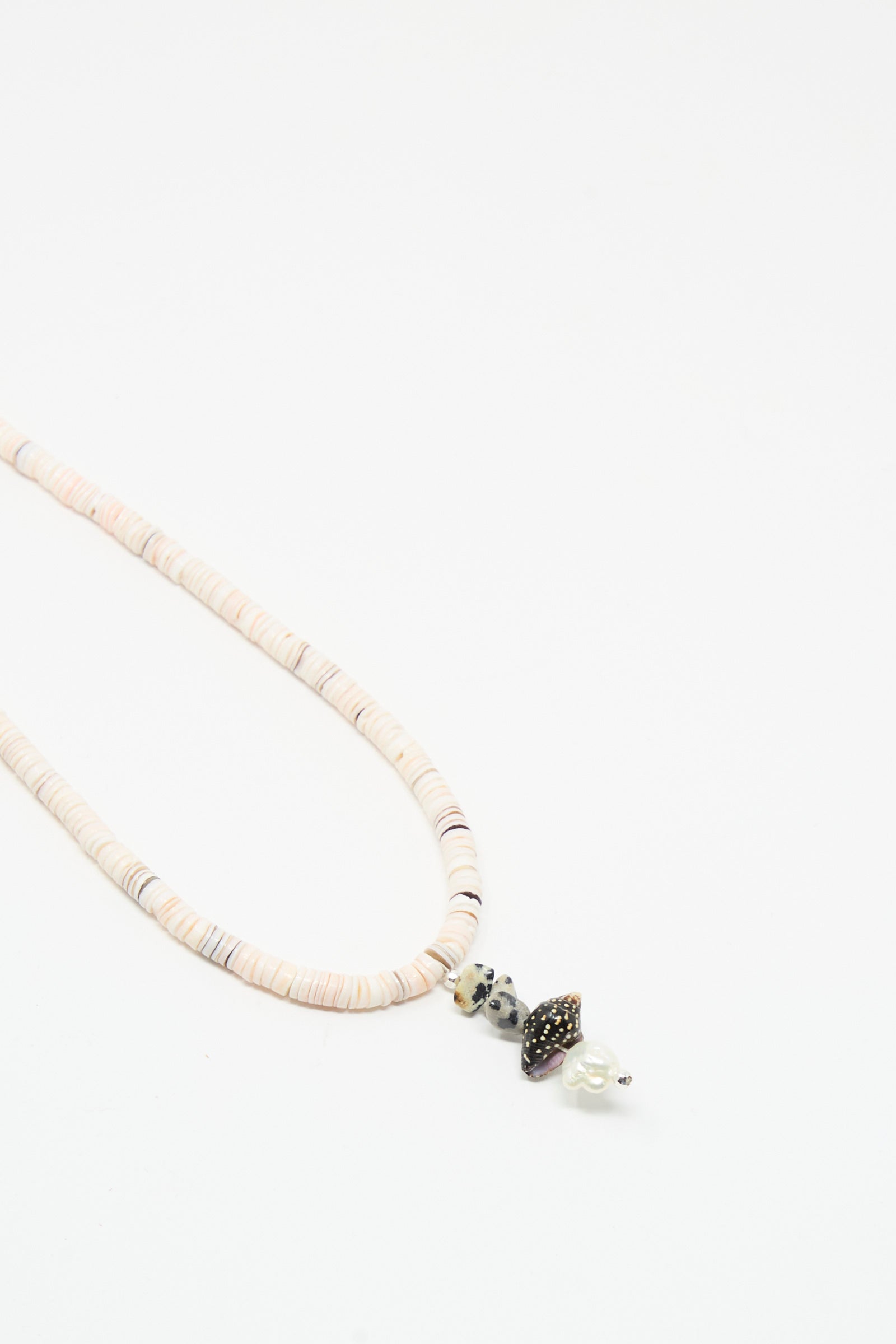 The Santangelo Pronto Necklace in Heishi Dalmatian Stack showcases light heishi shell discs and three unique decorative beads, including dalmatian jasper, beautifully displayed against a plain white background.