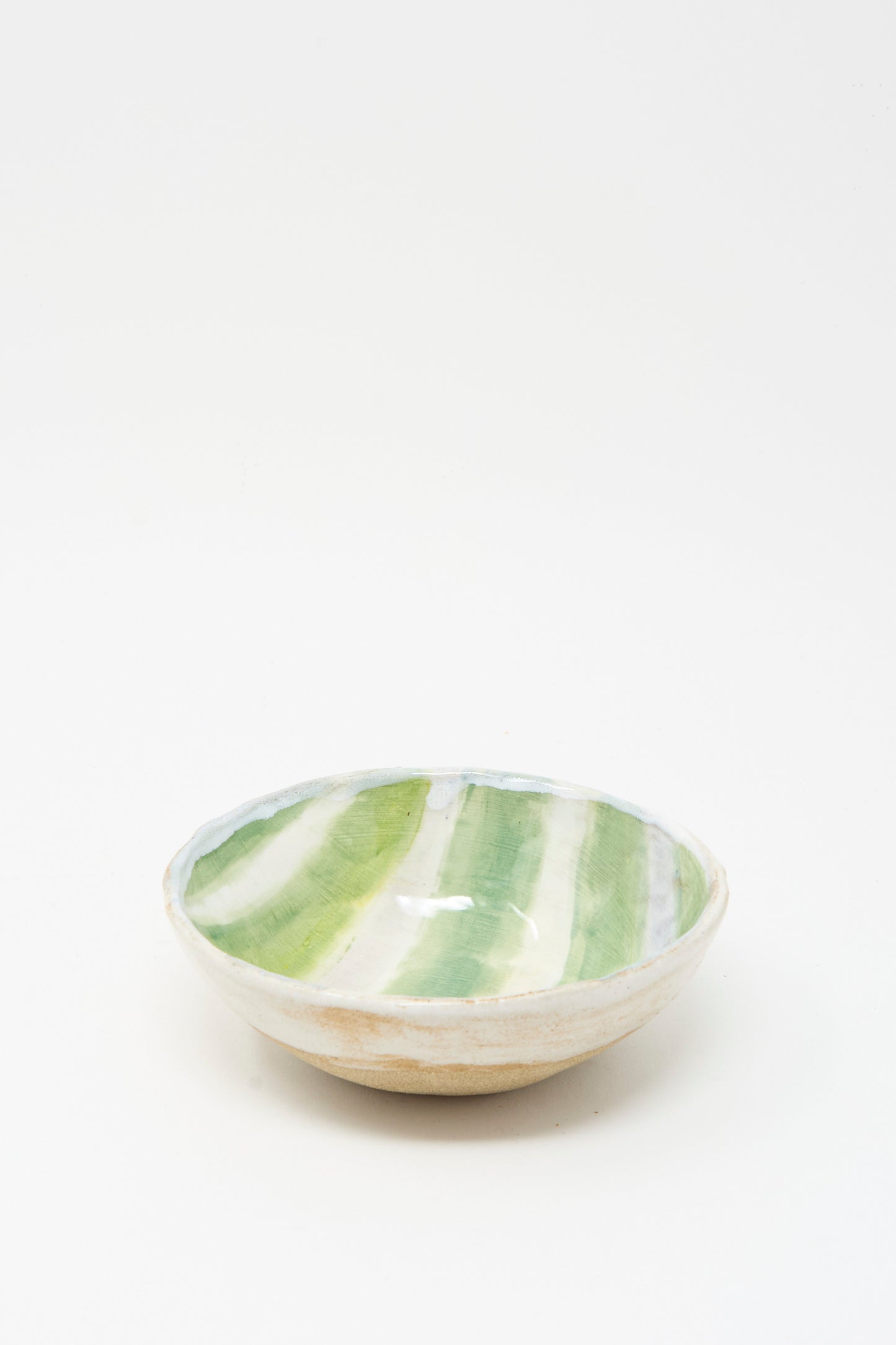 The Bowl in Green and White Stripes by Shino Takeda is a handmade ceramic piece from New York, featuring green and white stripes glazed inside, shown on a plain white background.