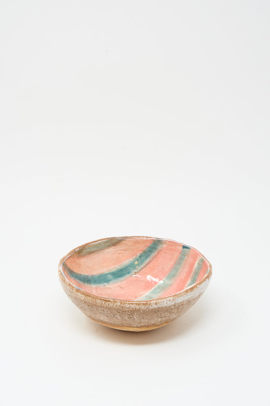 The Bowl in Green Stripe by Shino Takeda features a rough beige ceramic exterior and a pink glazed interior with green and orange stripes, handcrafted in New York.