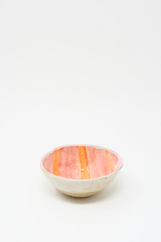 The Shino Takeda Bowl in Orange Stripe is a handmade ceramic piece from New York, featuring a white exterior and an interior with bold orange and red stripes, displayed on a plain white background.
