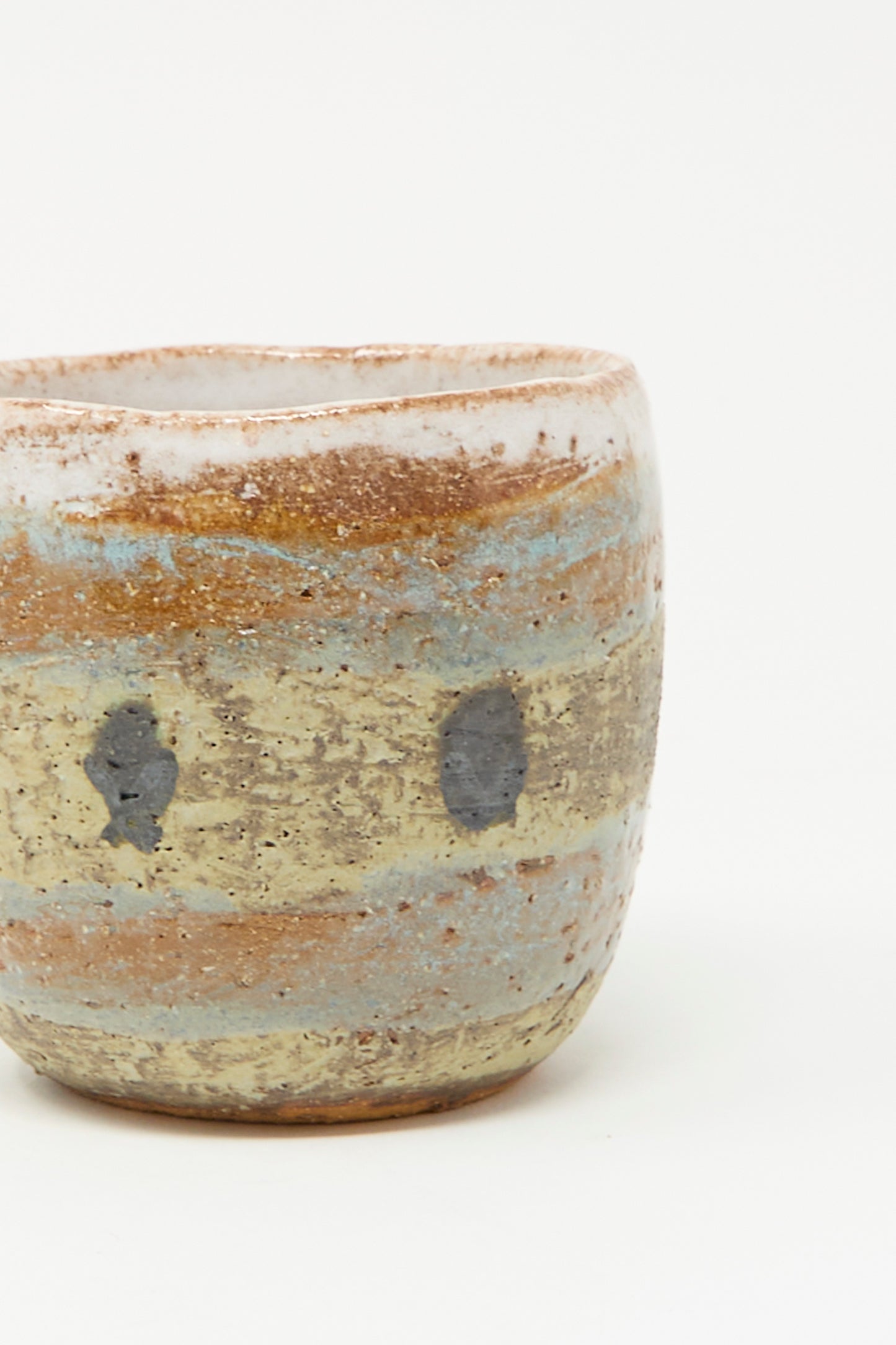 Cup in Dots I by Shino Takeda is a handmade, hand-painted ceramic cup from New York, with a rough texture, earthy brown, beige, and gray tones, and dark oval markings.