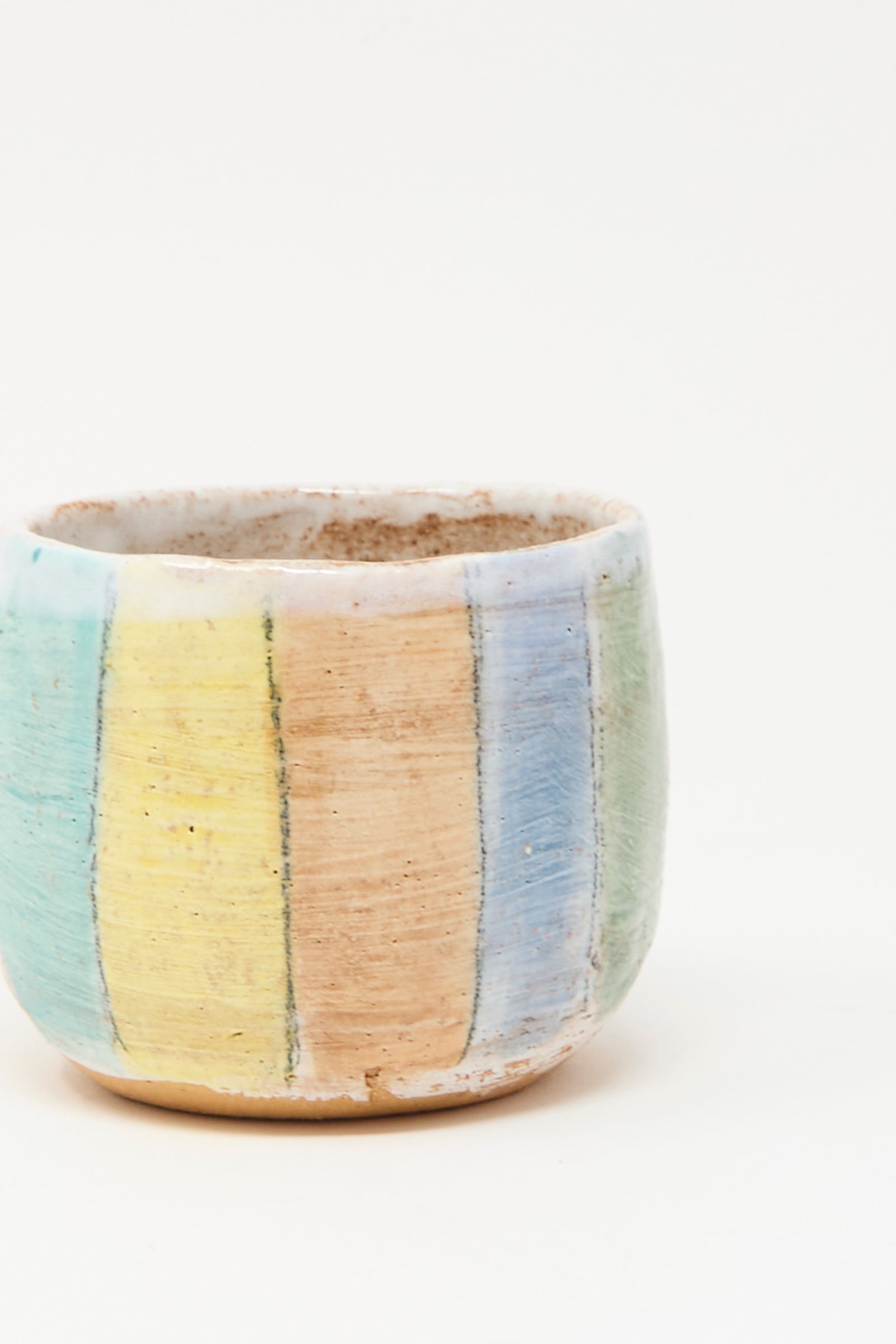 The Cup in Stripe I by Shino Takeda is a hand-painted ceramic cup with vertical pastel blue, green, yellow, and orange stripes on white, made in New York.