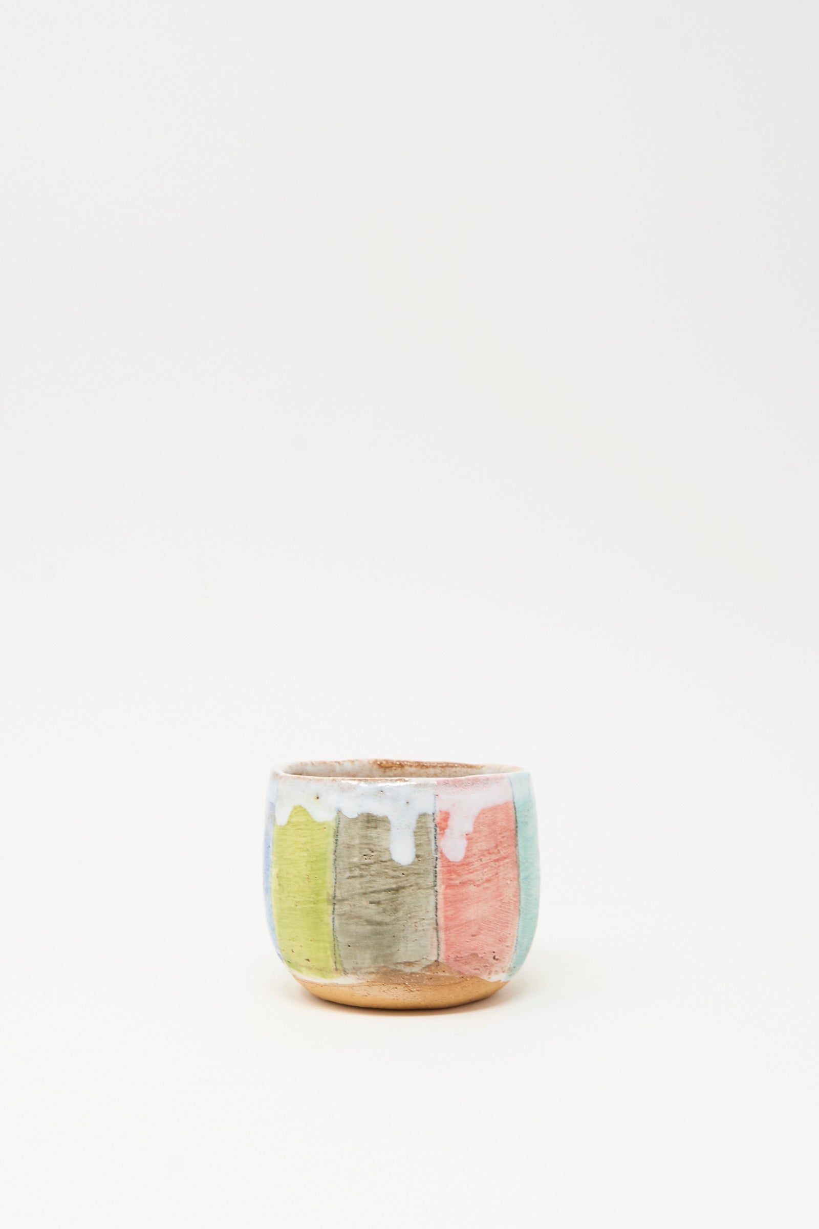 Cup in Stripe I by Shino Takeda is a small hand-painted ceramic pot with a matte finish, vertical pastel stripes, and white glaze dripping from the rim, shown against a plain white background.