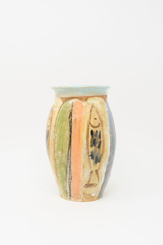 The Fish Vase in Multi Stripe by Shino Takeda is a handmade clay vase with a rounded shape, featuring vertical green, orange, blue, and tan stripes with black abstract accents—a vibrant piece for any room.