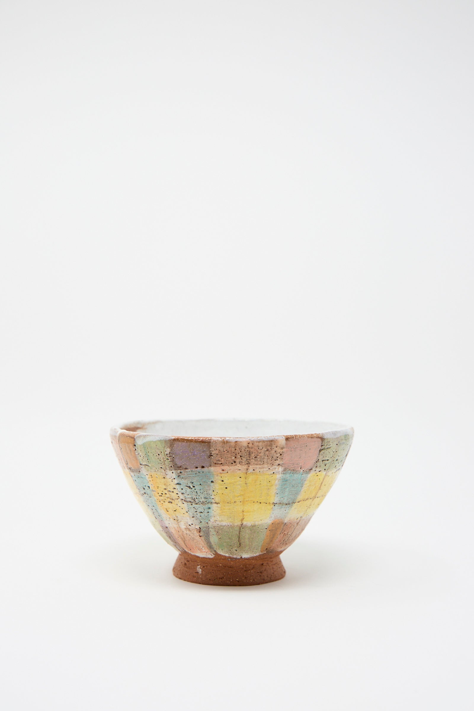 The Footed Bowl in Pastel Plaid by Shino Takeda features a textured surface decorated with a gentle plaid pattern in soft hues of blue, yellow, and pink.