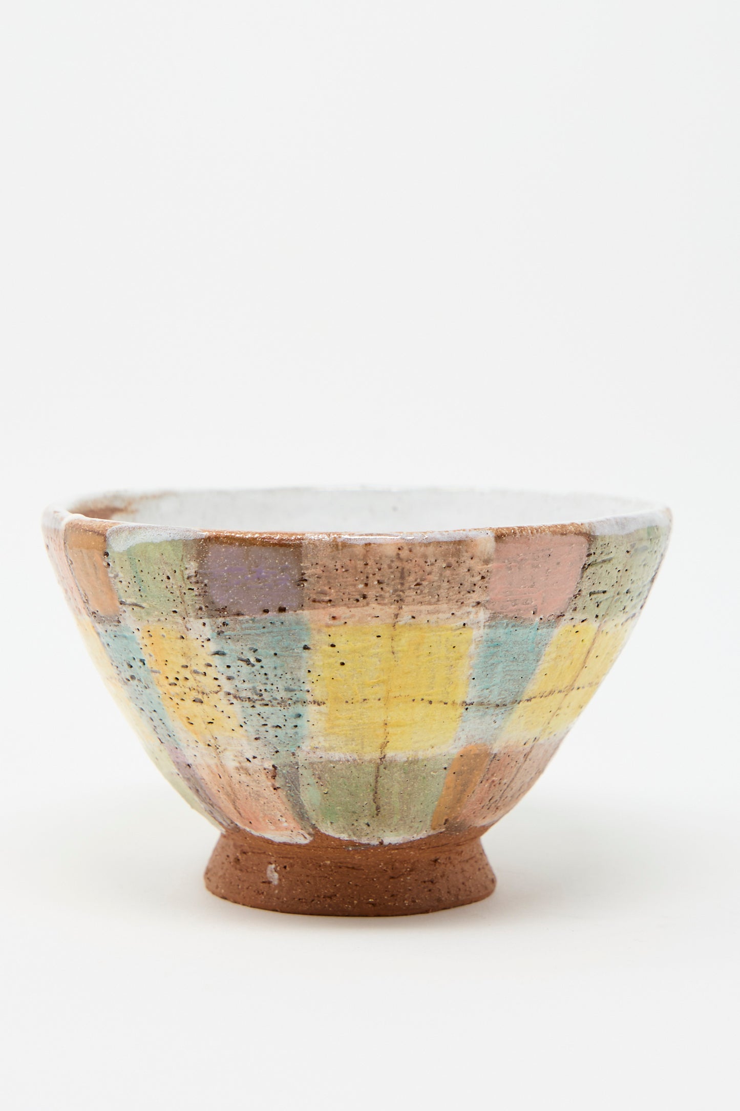 A Footed Bowl in Pastel Plaid by Shino Takeda, featuring a hand-built ceramic design with a speckled pastel plaid checkerboard pattern, sits on a white background.