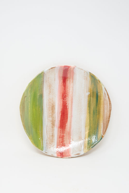 The Serving Plate in Red Green Stripe by Shino Takeda features handmade ceramic craftsmanship with vertical stripes in green, red, and brown on a crisp white background.
