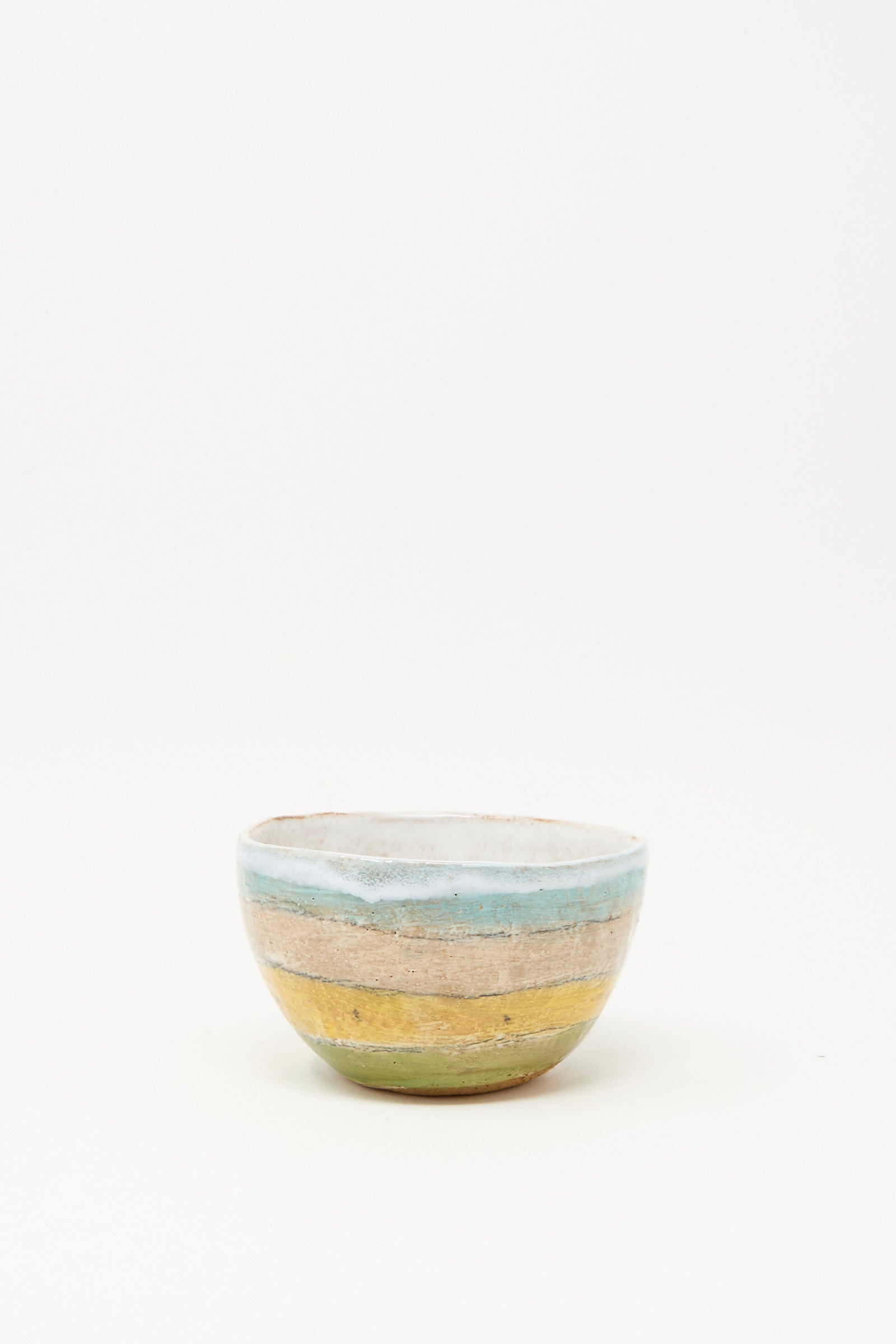 The Small Bowl in Stripe II by Shino Takeda is a handmade ceramic bowl from New York, featuring hand-painted blue, tan, and green stripes on a white background.