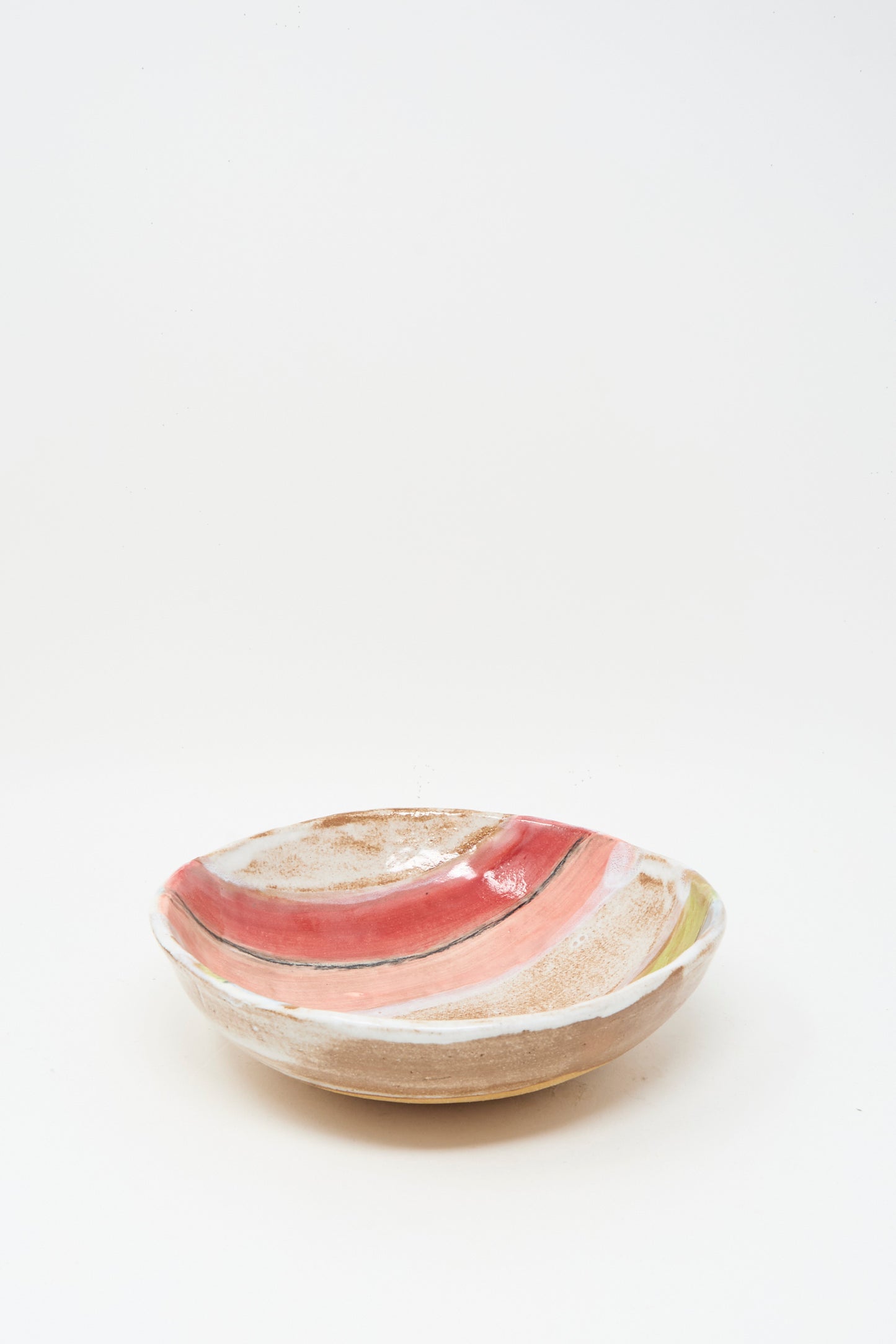 The Stripe Serving Bowl in Multi I by Shino Takeda is a shallow ceramic bowl with a matte finish and pink, white, and beige striped glazing inside. Made in New York. Shown against a plain white background.