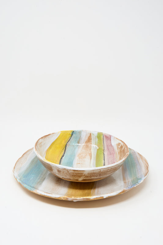 The Stripe Serving Bowl in Multi II by Shino Takeda is a ceramic bowl with hand-painted pastel stripes and a striped glaze in yellow, blue, green, and pink on white, crafted in New York.