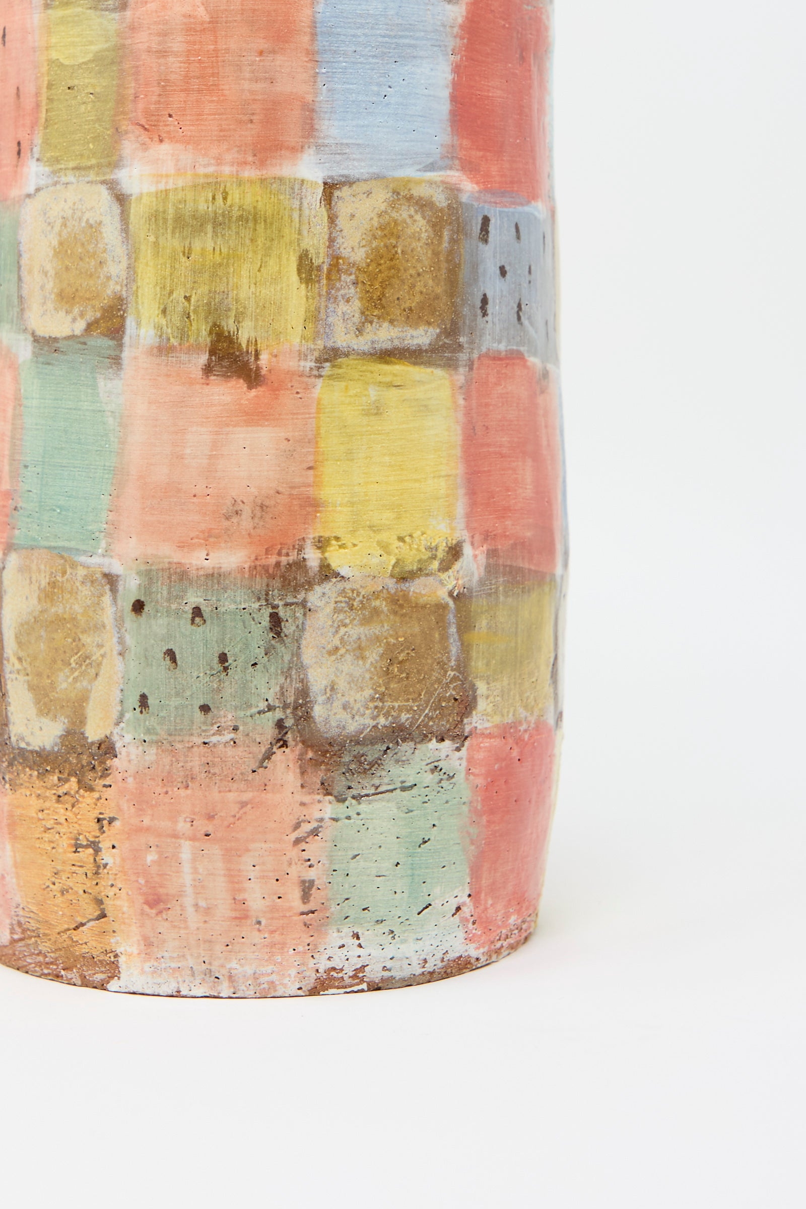 The Vase in Pastel Checker by Shino Takeda is a unique ceramic piece with a grid pattern of hand-painted squares in pastel shades of pink, yellow, blue, and green on a light background.