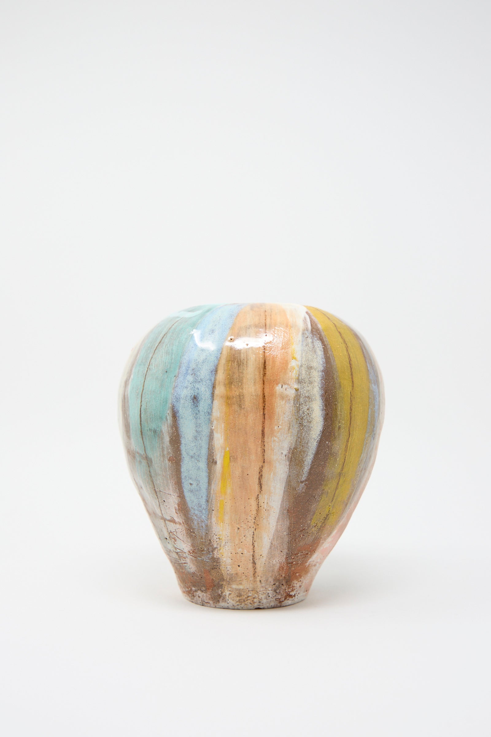 The Vase in Pastel Stripe by Shino Takeda: a round ceramic clay vase featuring vertical stripes in shades of blue, orange, yellow, and brown set against a white background. 