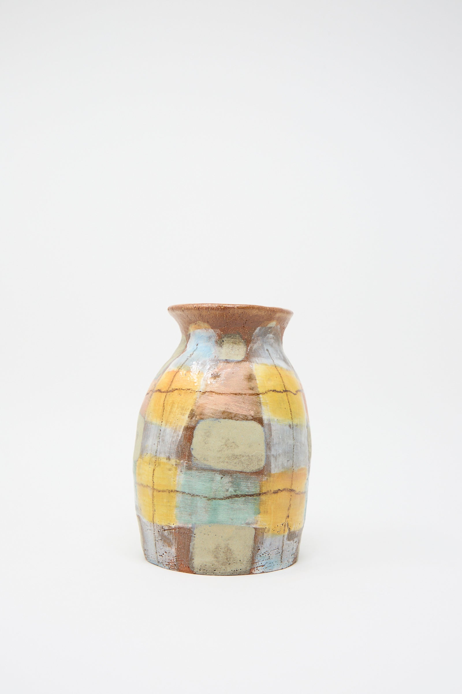 The Vase in Pastel Plaid by Shino Takeda is a hand-painted ceramic piece with a wide neck, showcasing an earthy checkered pattern in yellow, brown, and gray on a plain white background.