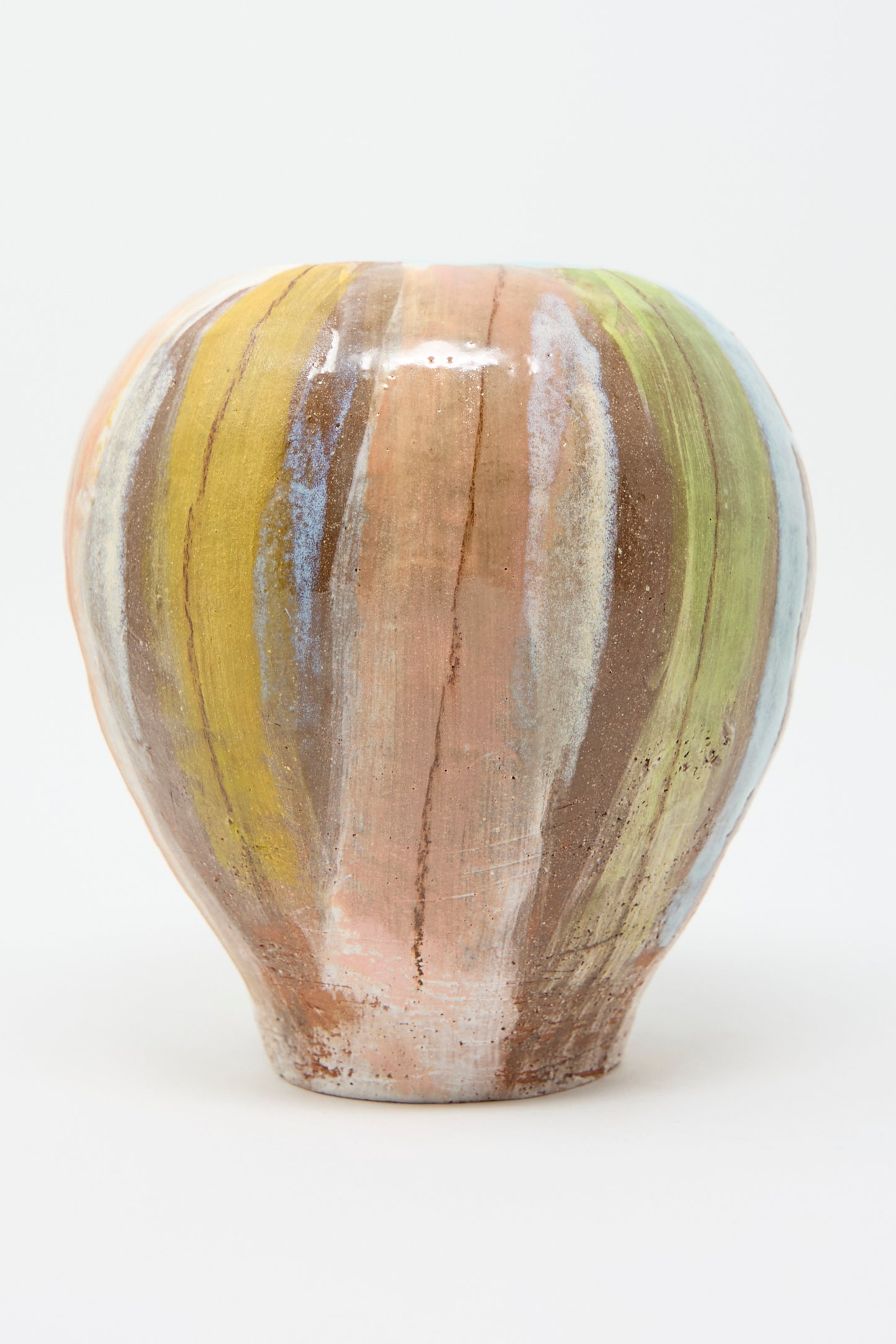 The Vase in Pastel Stripe by Shino Takeda showcases a round, hand-painted ceramic design with vertical multicolored earthy stripes in shades of brown, green, blue, and peach on a light background.