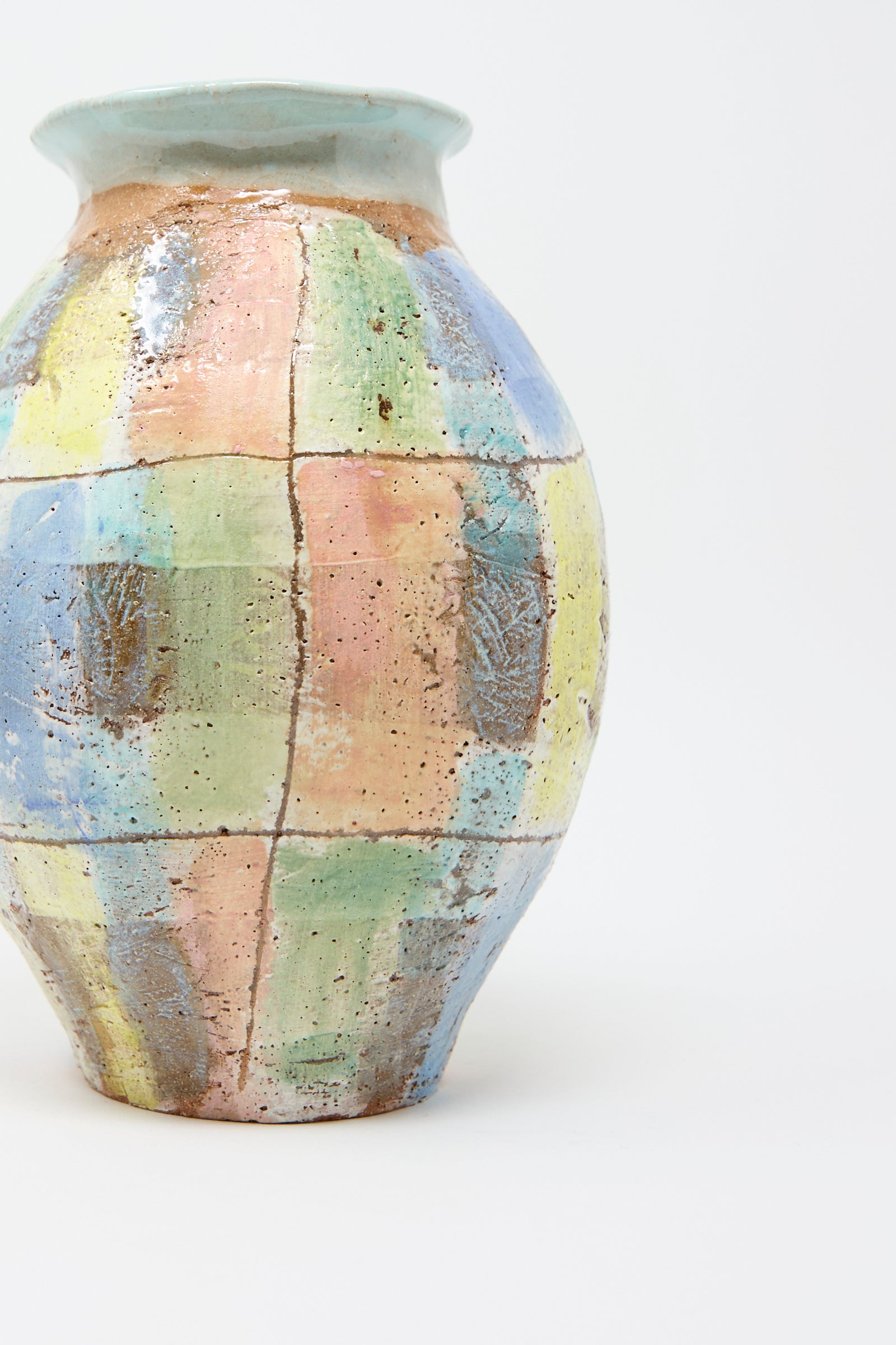 The Vase in Pastel Plaid with Blue by Shino Takeda is a hand-built ceramic piece showcasing a patchwork design with pastel plaid colors of blue, yellow, pink, and green set against a white background.