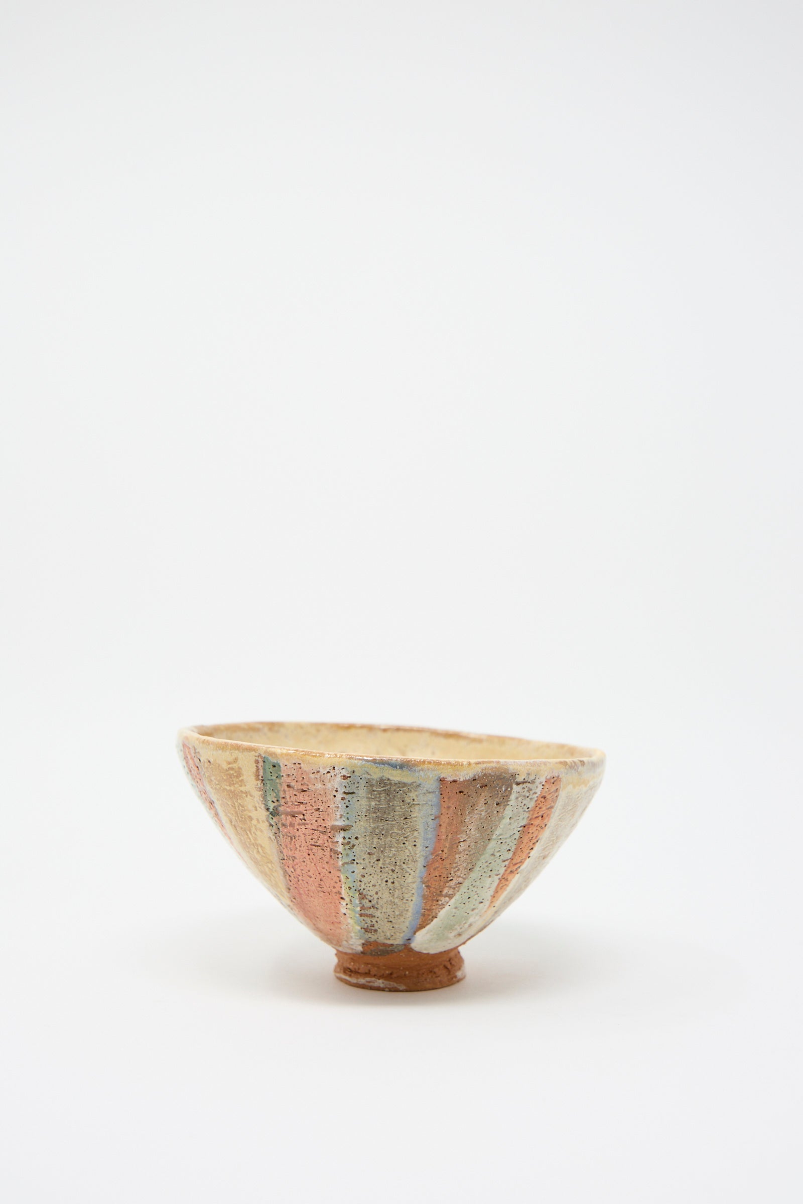 The Footed Bowl in Pastel Stripe by Shino Takeda is a small bowl featuring hand-painted vertical stripes in shades of pink, blue, and beige on a simple white background.