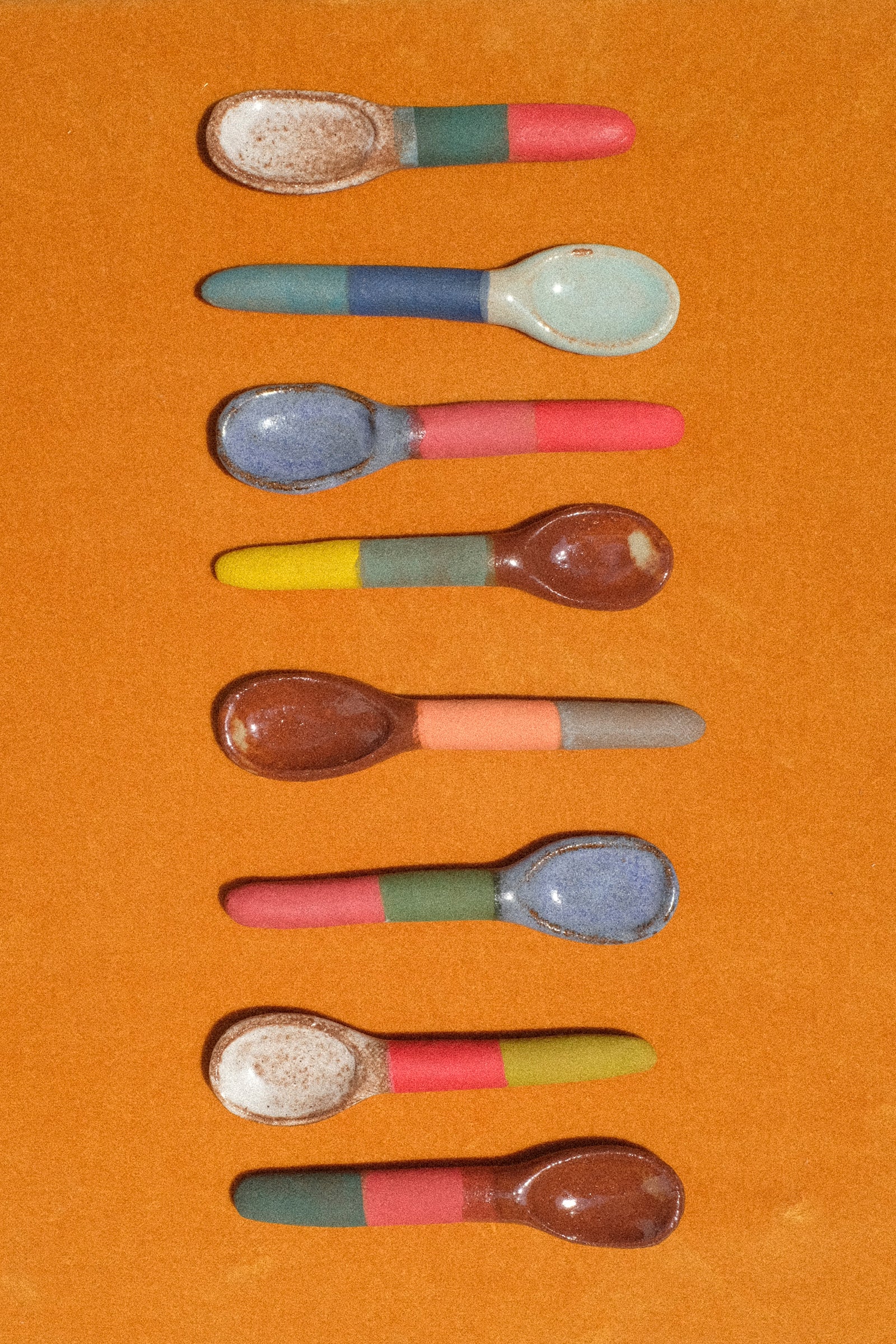A still image of hand-painted spoons by Shino Takeda on a orange velvet. 