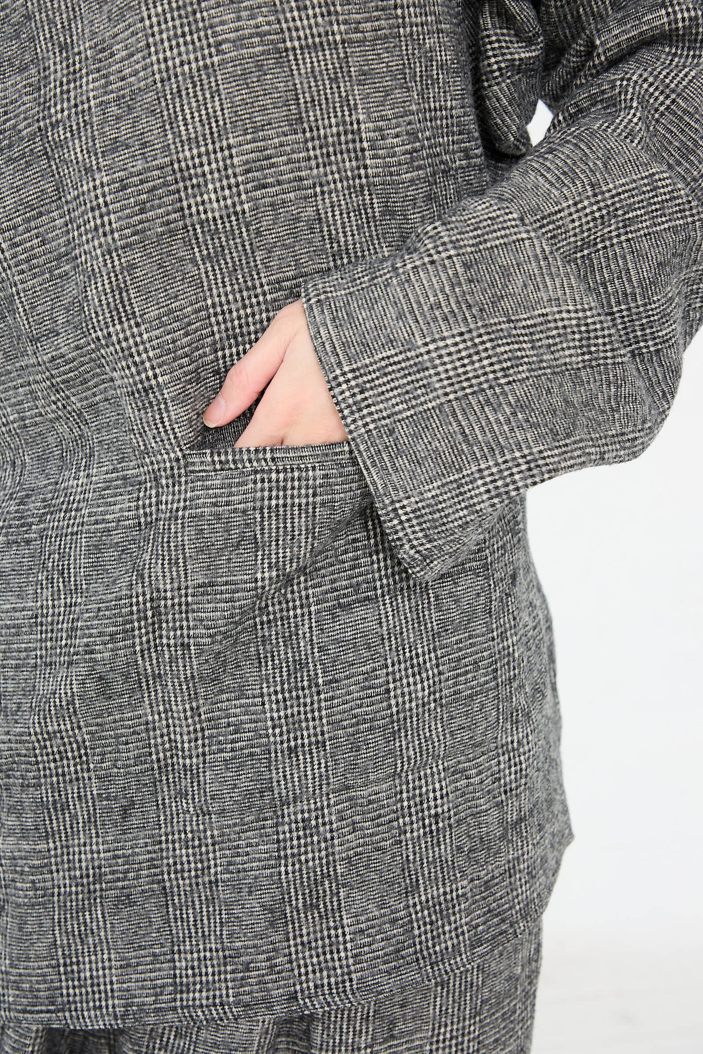 A close-up of a person wearing the Cotton Wool Washed Biba Top in Mid Grey by Sofie D'Hoore, with one hand placed in the front pocket.