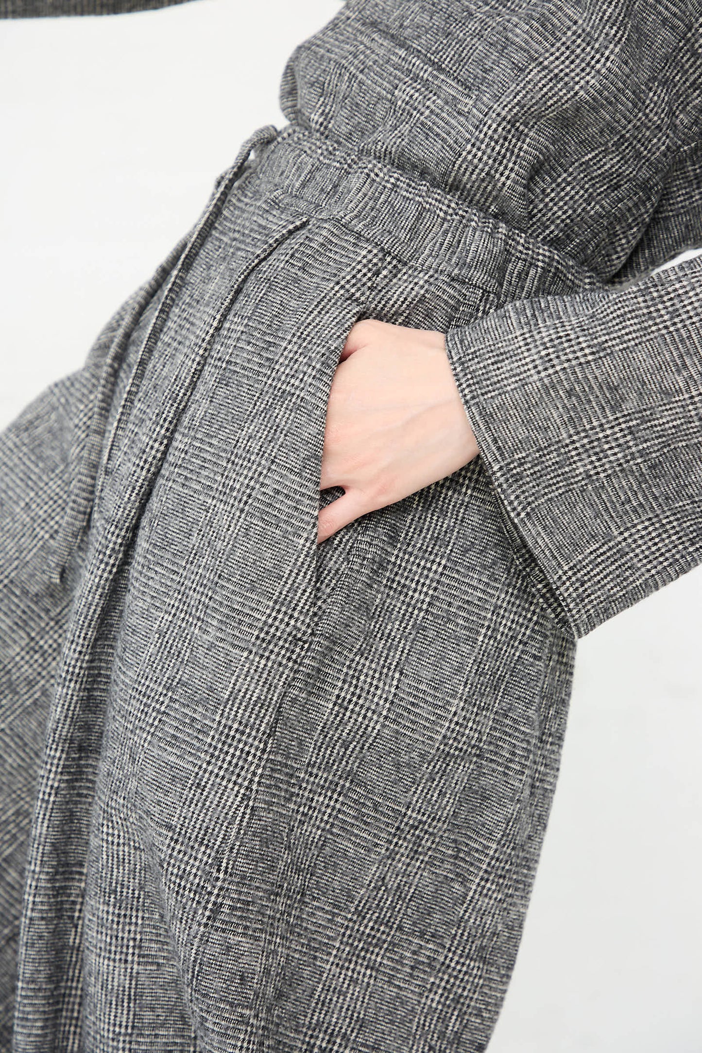 Close-up view of a person wearing the tonal grey Cotton Wool Washed Palau Pant in Mid Grey by Sofie D'Hoore, featuring wide leg pants with a hand in the pocket.