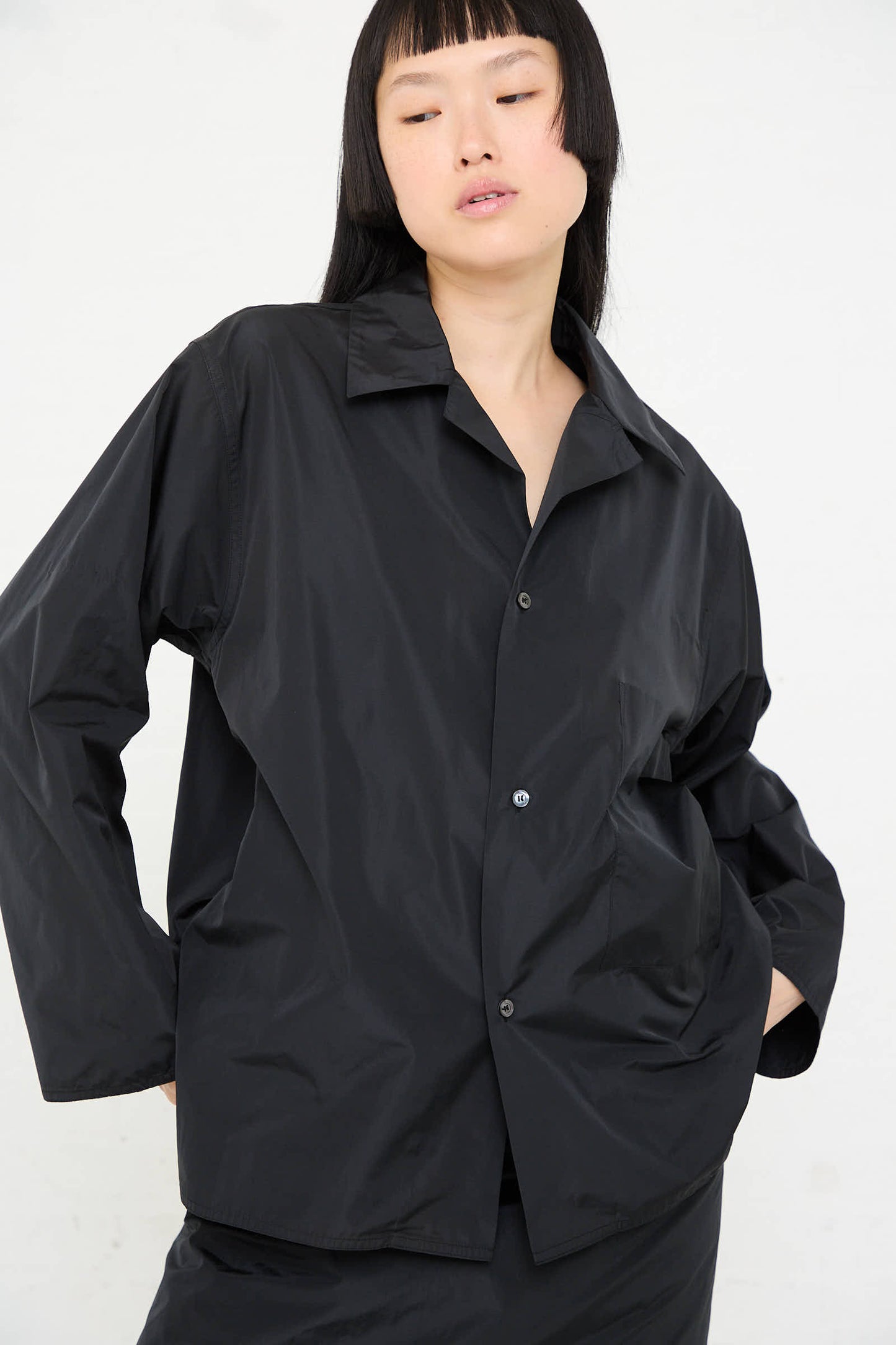 A person wearing the Taffeta Barry Shirt with Patch Pocket in Black by Sofie D'Hoore poses against a plain white background.