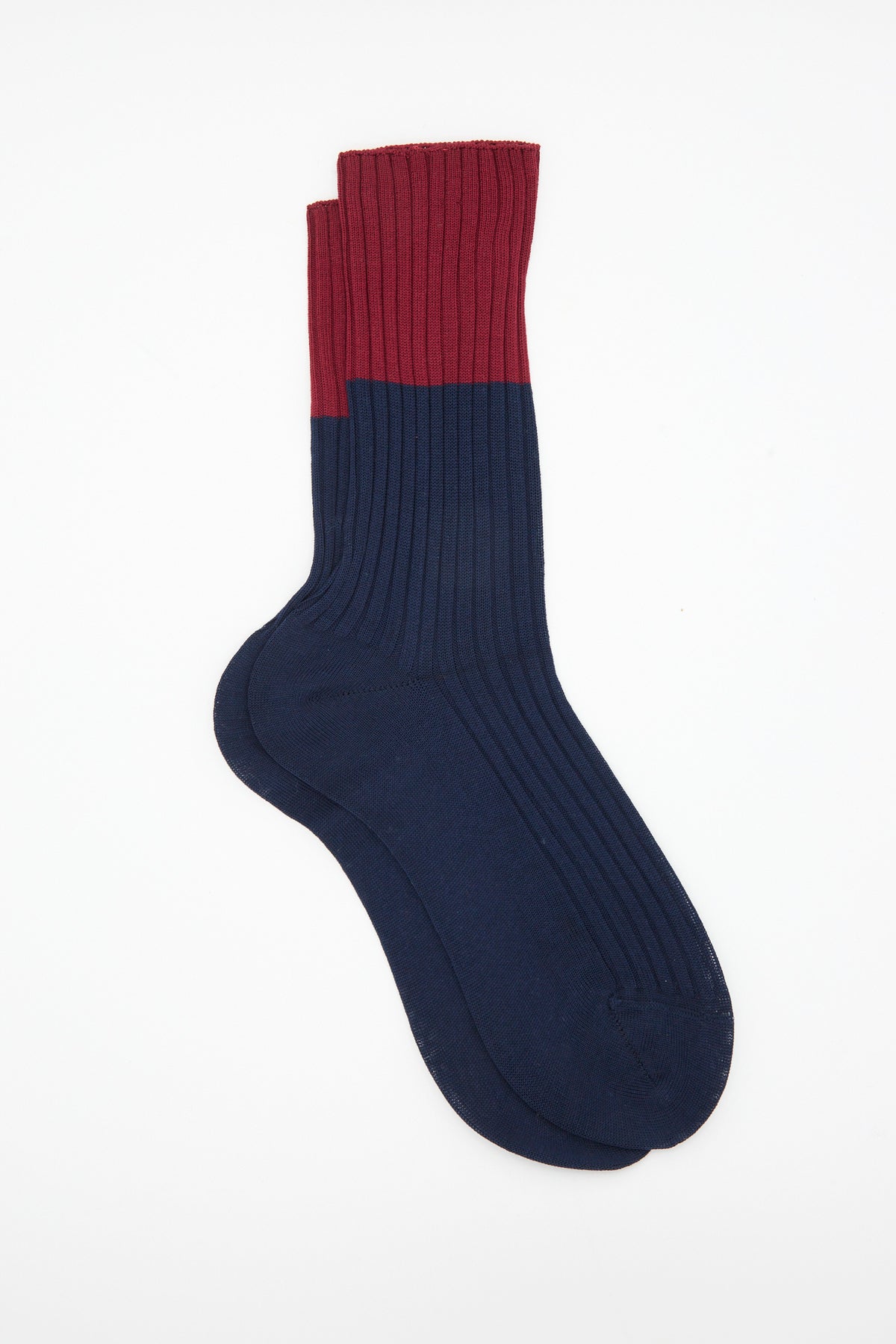 Sofie D’Hoore Bi-Colored Four Rib Sock in Navy, a mid-calf ribbed sock featuring a navy blue foot and a burgundy cuff.