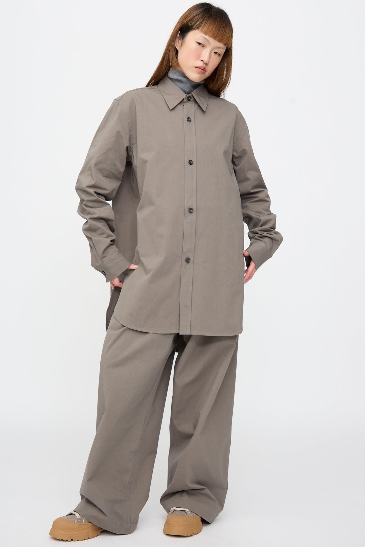 A person wears a grey Brushed Cotton Voile Breg Shirt over matching wide-leg trousers, with a grey turtleneck visible underneath.