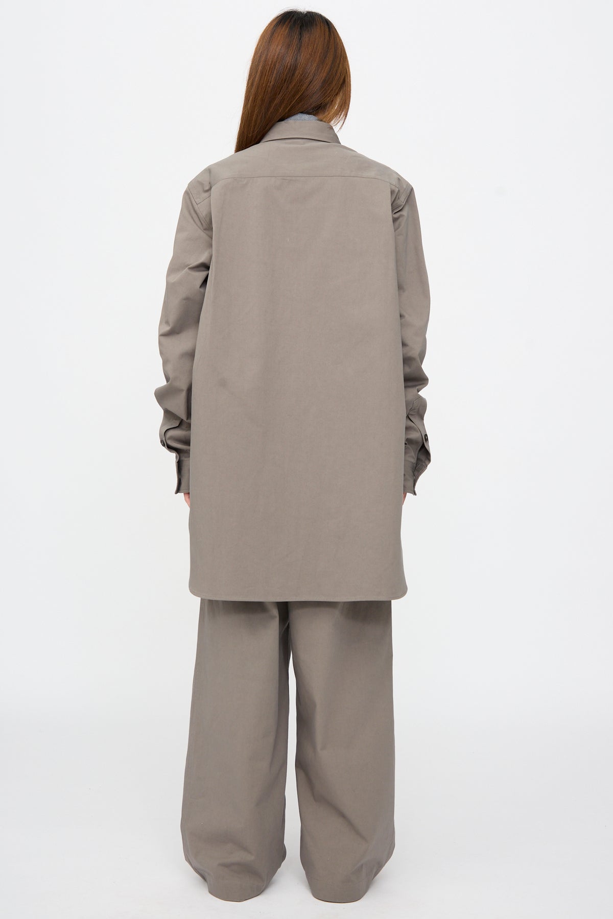 A person seen from behind wearing an oversized, long-sleeved Brushed Cotton Voile Breg Shirt in Turtle and matching wide-leg trousers.
