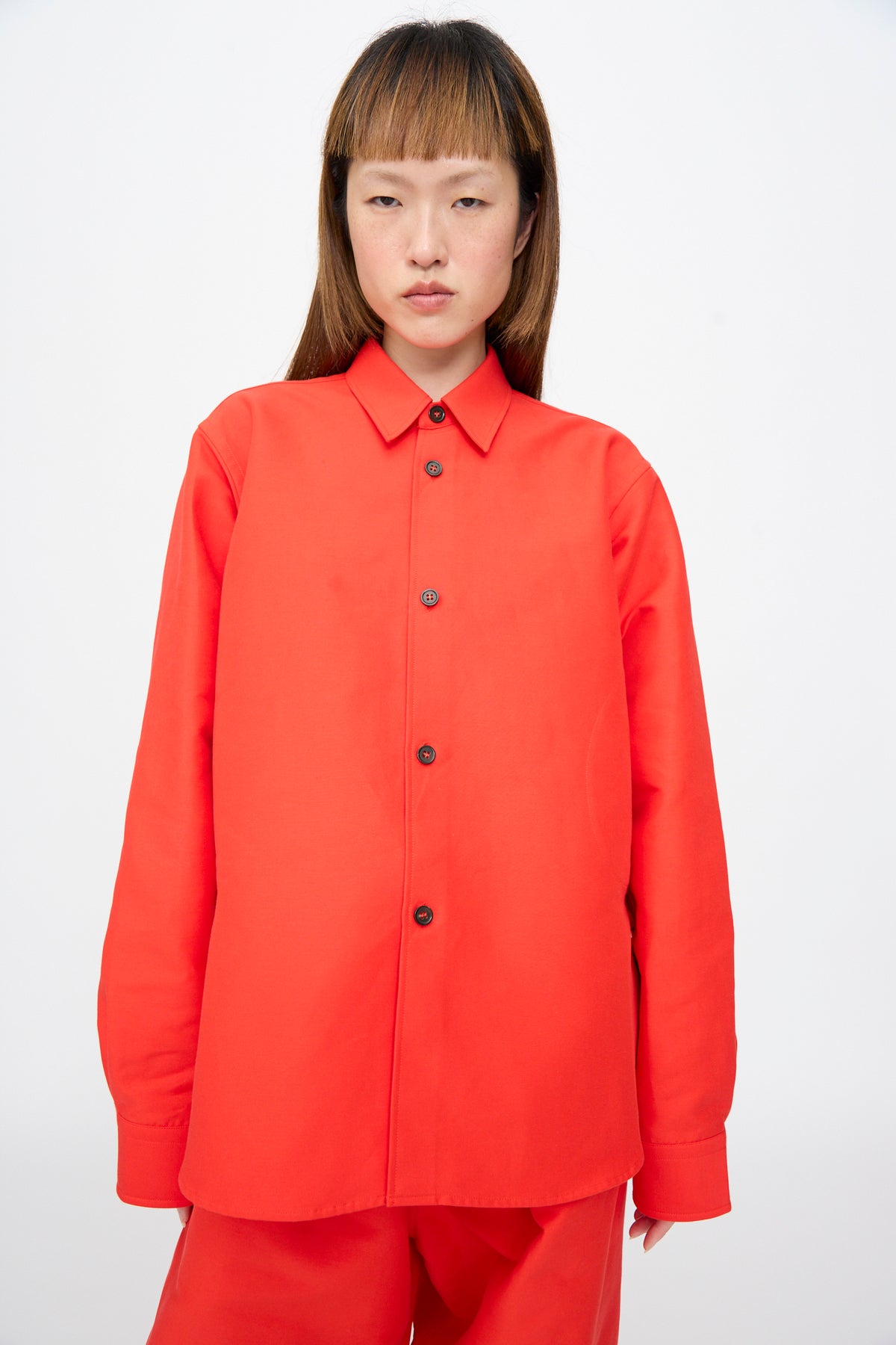 Sofie D’Hoore Cotton Duchesse Brant Shirt in Fire: an oversized, long-sleeved, bright red button-up with a classic collar and a hi-low hem.