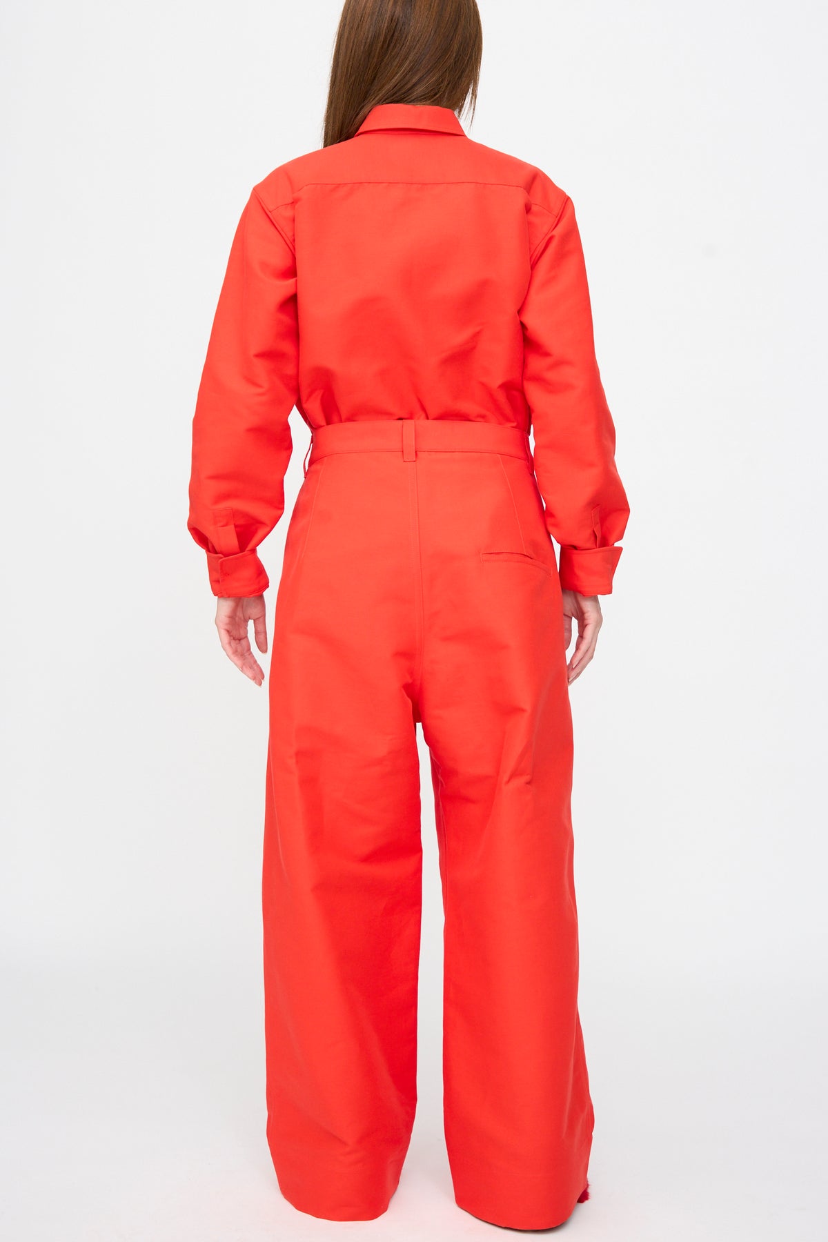 Back view of a person wearing a bright red, oversized-fit Cotton Duchesse Piaf Pant in Fire jumpsuit with a collared top and wide-leg trousers.