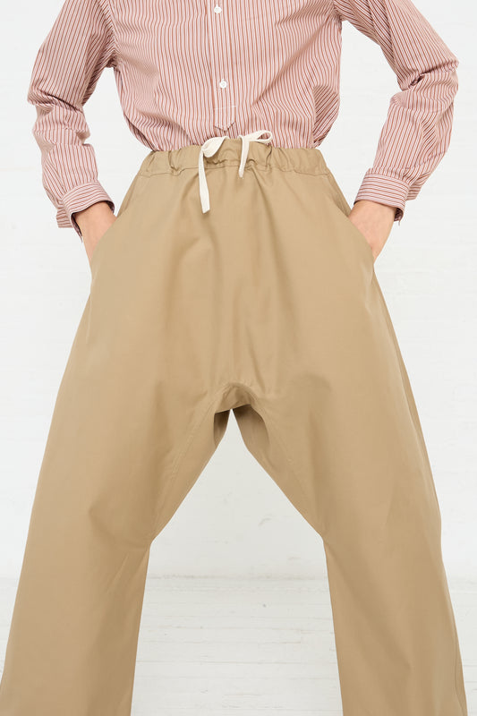 A woman in Sofie D'Hoore's Crisp Cotton Plof Pant in Dune (Tan). Front view and up close.