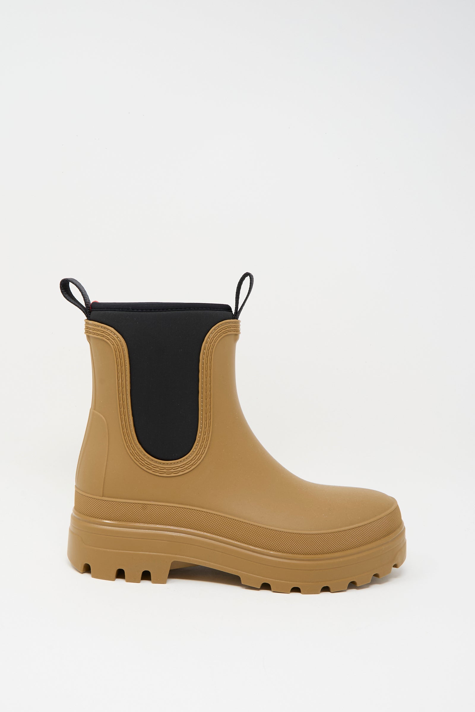 The Falk Rainboot in Caramel by Sofie D'Hoore features water-repellent rubber, black elastic side panels, a neoprene opening, pull tabs, and a thick treaded sole, shown against a plain white background.