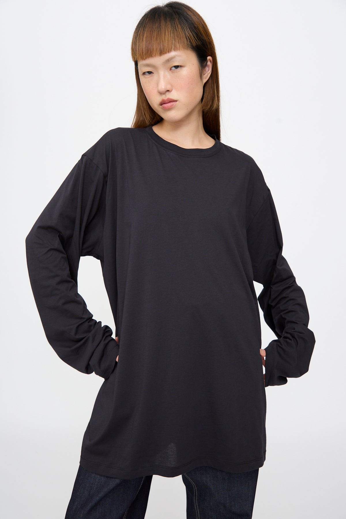 A person wearing a black Fine Cotton Jersey Toledo Tee in Cosmos, an oversized fit long-sleeve cotton jersey T-shirt.