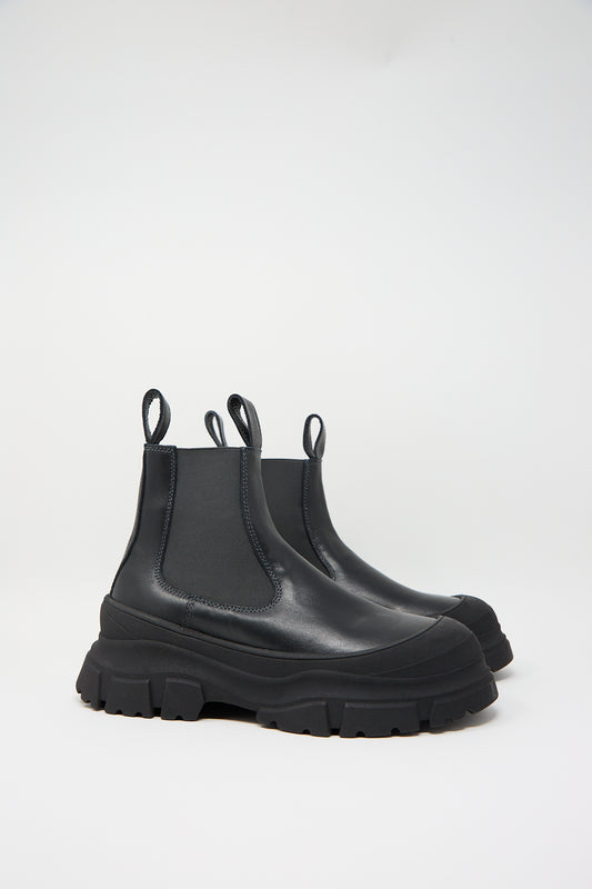 A pair of black Nappa Leather Fabulous Boot in Black by Sofie D'Hoore, featuring thick, rugged soles, a rubber cap toe, and pull tabs, displayed on a white background.