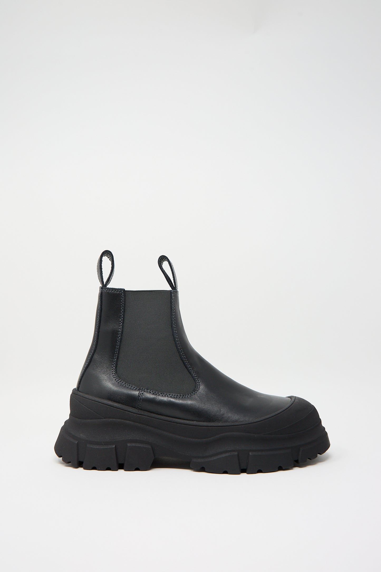 The Nappa Leather Fabulous Boot in Black by Sofie D'Hoore, featuring rubber cap toes, chunky rubber soles, and elastic side panels, is set against a plain white background.