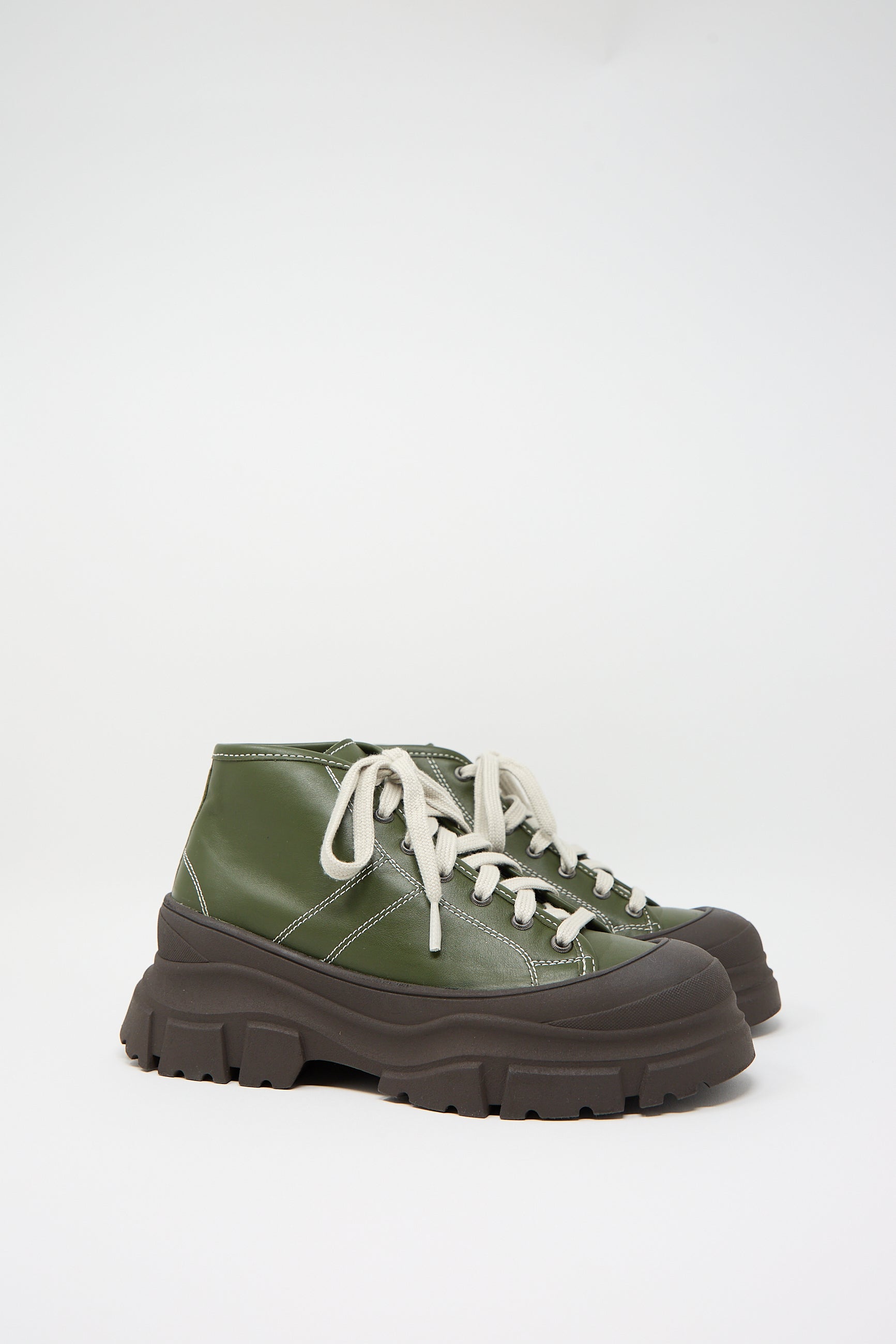 A pair of Nappa Leather Fairway Sneakers in Forest by Sofie D'Hoore, featuring a chunky platform design with white laces and a rubber cap toe, is displayed against a plain white background.