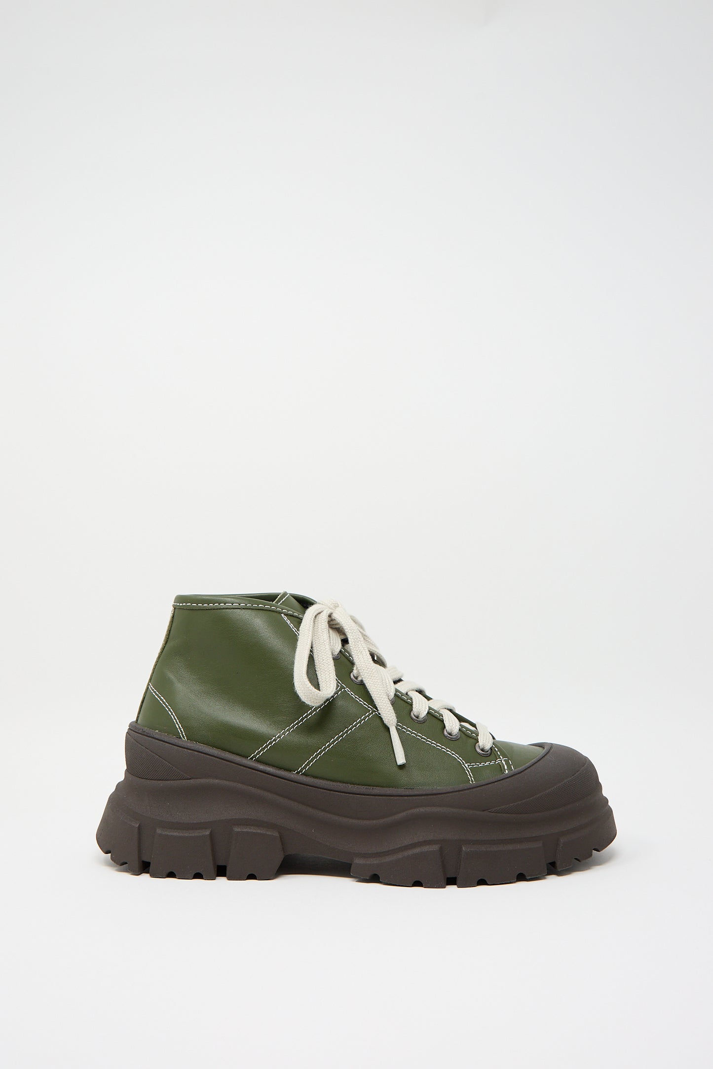 The Nappa Leather Fairway Sneaker in Forest by Sofie D'Hoore is a green, high-top platform sneaker featuring white laces, a thick black sole, and a rubber cap toe, displayed against a white background.