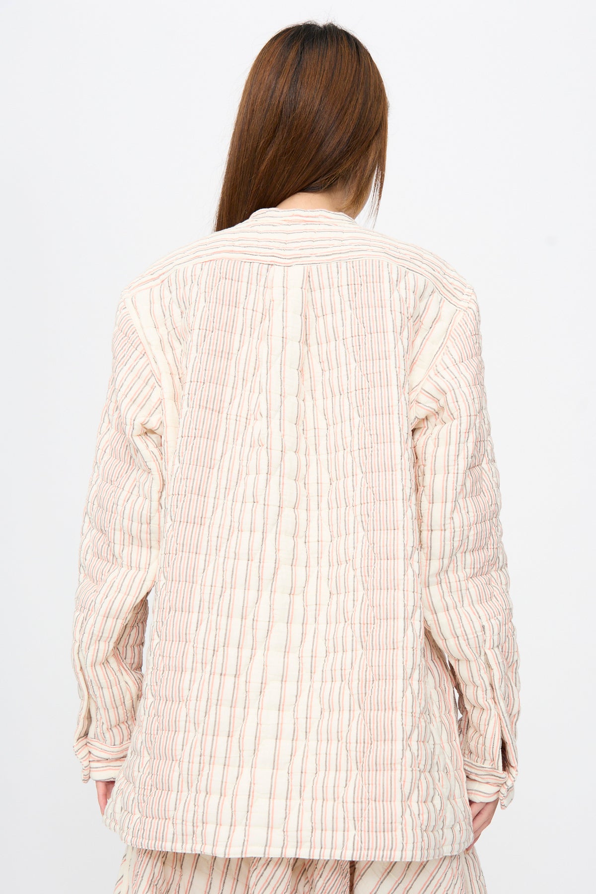 Back view of a person wearing a Sofie D’Hoore Quilted Cotton Bela Shirt in Red Stripe, featuring a relaxed fit, long sleeves, and vertical red and grey stripes.
