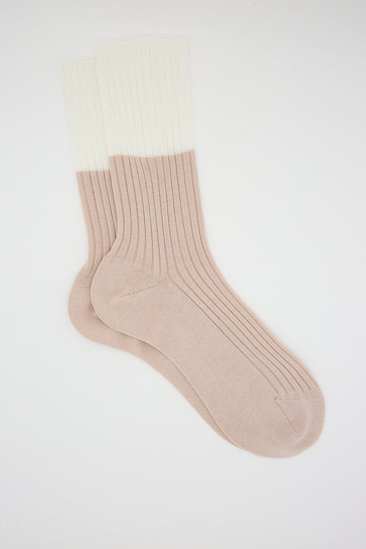 A pair of Sofie D’Hoore Ribbed Cotton Four Crew Sock in Ivory and Nude on a white background.