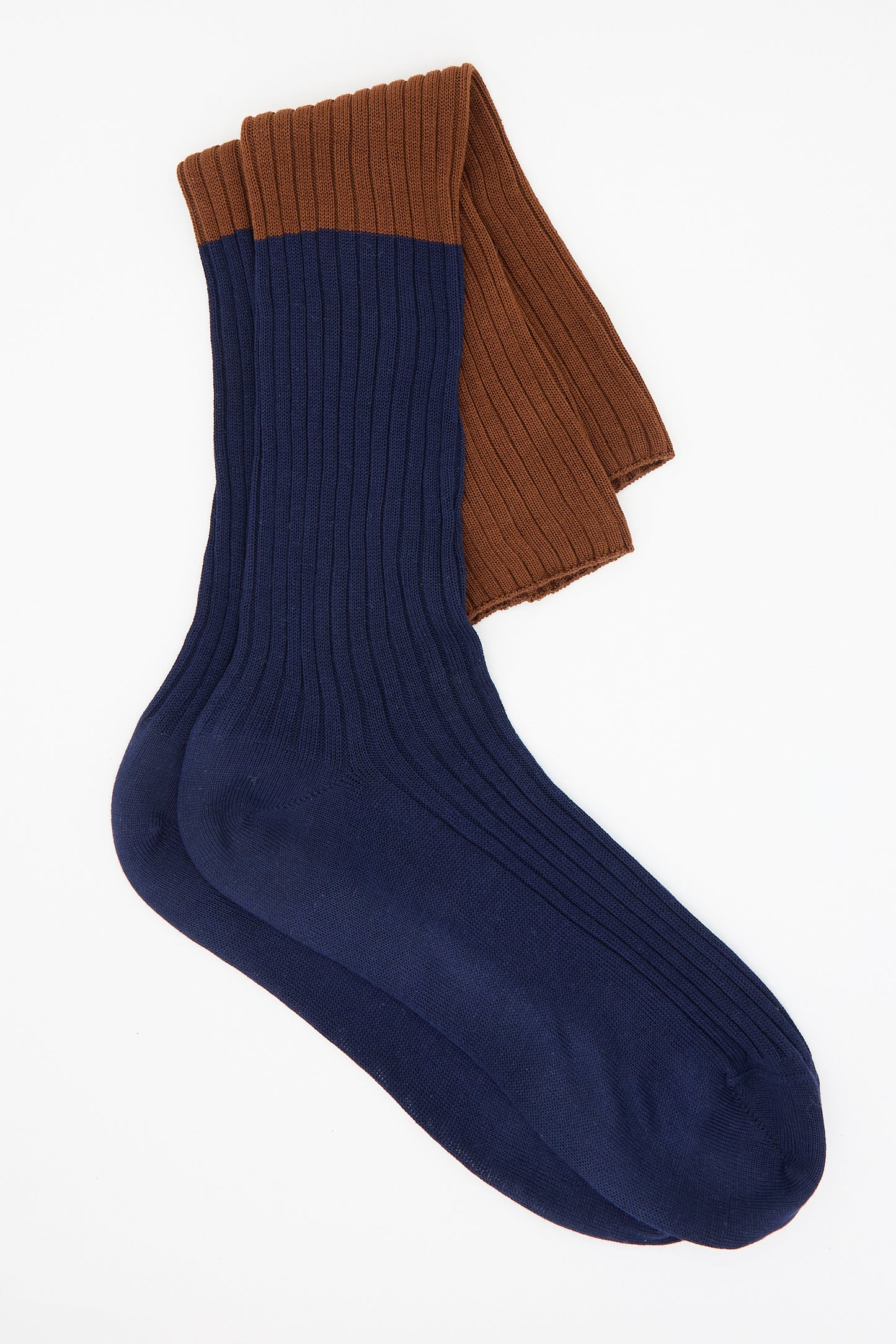 A pair of Sofie D'Hoore's Ribbed Cotton Friday Knee High Socks in Rust and Navy, featuring blue feet and brown cuffs, laid flat on a white background.