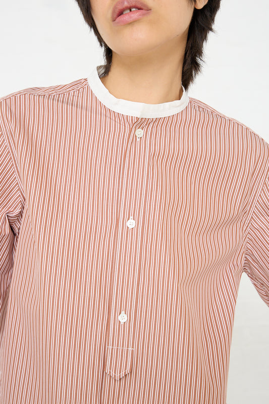 A woman wearing a Sofie D'Hoore Woven Cotton Boyd Shirt in Brick Stripe and Ivory.