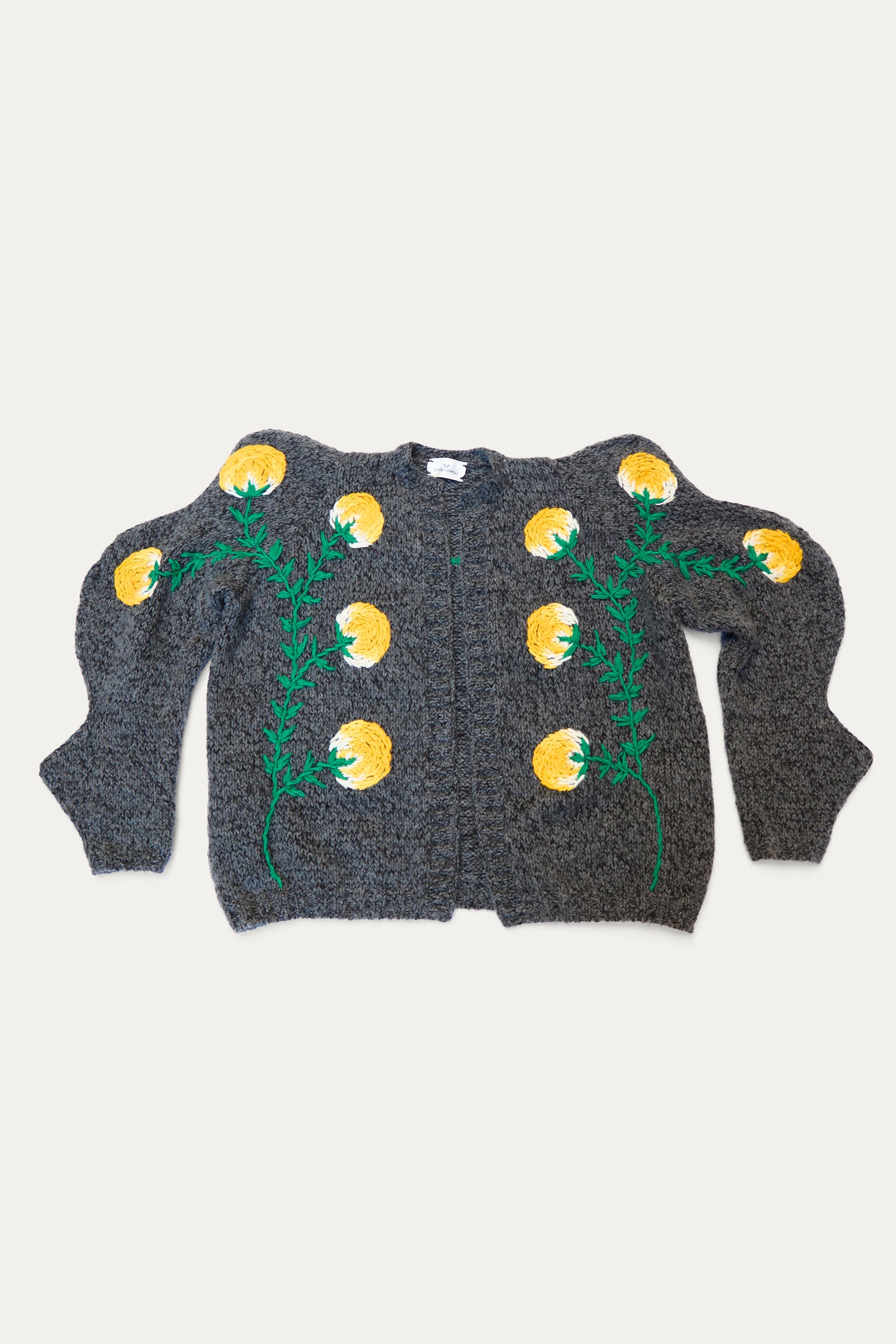 The Sofio Gongli Cardigan with Yellow Flower in Grey is a cozy mohair wool blend featuring puffed sleeves and embroidered yellow flowers with green stems on the front.